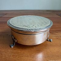 Full view of round sterling silver jewelry box on three feet