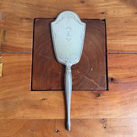 Front view of sterling hand mirror showing mirror glass and overall shape