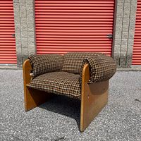 Three-quarter view of chair showing wood sides and upholstery