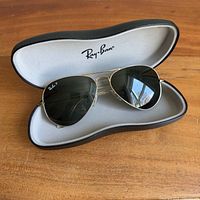 Sunglasses resting inside open Ray-Ban case