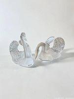 Both Lalique swan figures side by side