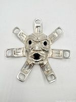 Front view of the sun mask pendant showing facial details and rays