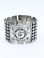 Front view of sterling silver panel bracelet showing scrollwork, animal motif, bead separators
