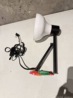 Side view of lamp showing arm, shade, cord and taped mount