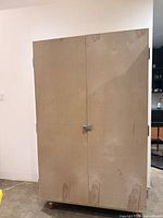 Front view of closed plywood cabinet on casters with latch
