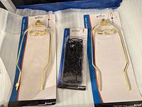 Two packaged brass harps and packaged black chains
