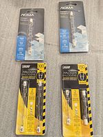 Four retail blister packs: two NOMA single halogen bulbs, two FEIT Electric 2-packs