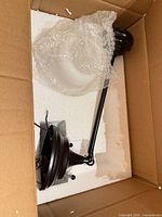Pendant fixture components in box: downrod, ceiling canopy, shade wrapped in bubble wrap