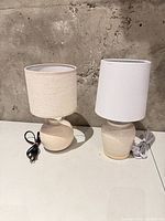 Two ceramic table lamps with shades side by side showing overall condition and cords