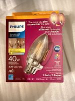 Angled front view of Philips Warm Glow LED candle bulb 3-pack package