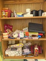 Cabinet shelves showing soaps, manicure tools, cosmetic bags, ceramic containers, decorative glass bottle