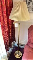 Full view of brass floor lamp with shade