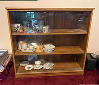 Full front view of cabinet showing wood finish and glass doors