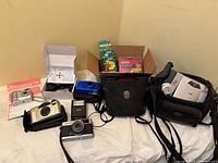 Group shot of all cameras, flash, film boxes, memory cards and bags