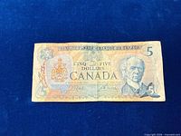 Front view of 1979 Canadian $5 banknote showing denomination, portrait, coat of arms