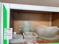Shelf view showing frosted serving bowl, platter, small bowls, clear bowl and square dish