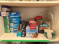 Shelf containing assorted Ziploc bag boxes, food wrap rolls and coffee filters