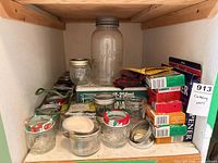 Shelf with large mason jar, small jars, boxed lids, wax discs