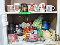 Cabinet showing mugs, tea tins, infusers and accessories