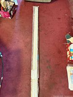Full length view of rolled shade in packaging