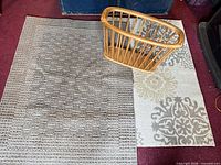 Two rugs side by side with wooden magazine basket placed on beige rug