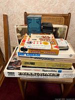 Stacked view of all boxed board and card games on chair