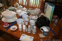 Full view of all items arranged on a wooden table including punch bowl, cups, salt and pepper shakers, wooden pitcher and cups, rose dishes, and pottery mug.