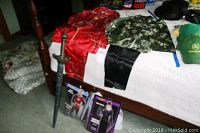 Bed with costumes including a red princess outfit, green floral vest, two swords on the floor, and hats/caps