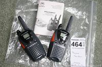 Pair of Motorola Talkabout FRS110 two-way radios with manual laid out on a clear plastic sheet