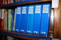 Photo of six blue binders labeled Easy Home Repair on a wooden bookshelf.
