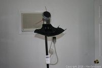 Photo of Craftsman gas weed trimmer standing vertically, showing the cutting head with red string lines and motor housing.