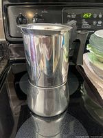 Full view of stainless steel stovetop espresso maker on stove
