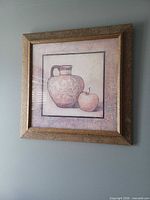 Close-up of framed print with pitcher and apple