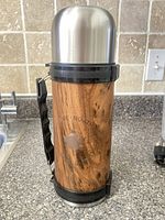 Full thermos with cup in place, showing woodgrain exterior and handle