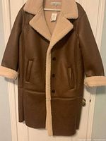 Front view of brown sherpa coat on hanger