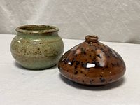 Green glazed vase and brown bud vase, front view