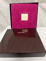 Album lid removed showing purple velvet cover and branded box