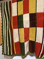 Blanket hanging showing left half with patchwork and striped panels