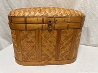 Front angled view of wicker storage chest showing lid, closure, and weave pattern