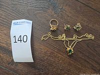 Entire jewellery set laid out: ring, earrings, pendant on chain