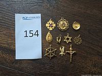 All 10 gold pendants/charms with reference tag