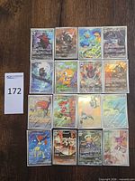 All 16 sleeved illustrated holo cards laid out for overview