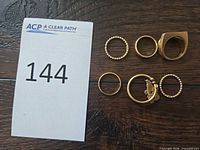 Six rings displayed next to lot card