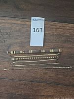 All six bracelets laid out on wood surface for overview