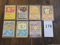 Group shot of seven Pokémon cards in toploaders