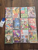All 12 Nintendo Switch cases and PSP UMD arranged on floor