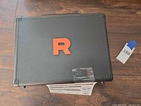 Closed black case with red “R” logo top view