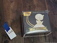 Front view of sealed Elite Trainer Box in acrylic case