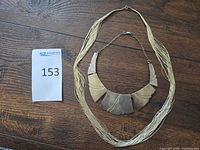 Full view of entire necklace showing multi-strand wires, bib panels and clasp