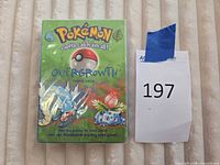 Front view of sealed Overgrowth theme deck box next to lot number card